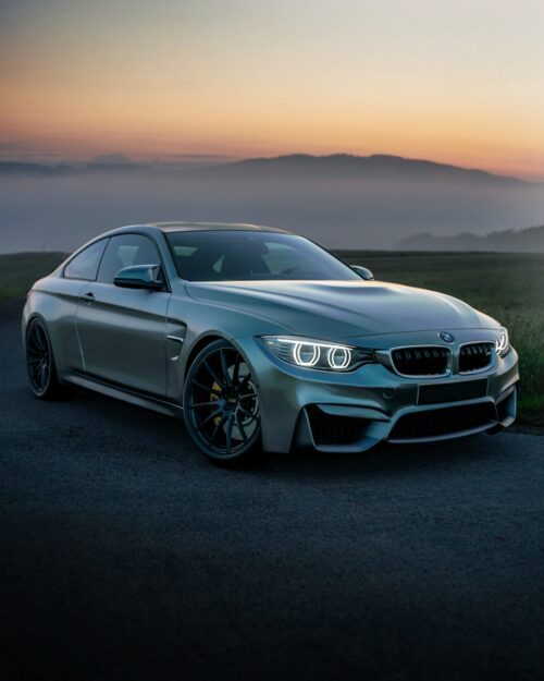 BMW Grise avec phares allumés, choisie pour illustrer un article sur l'acht ou la location de BMW