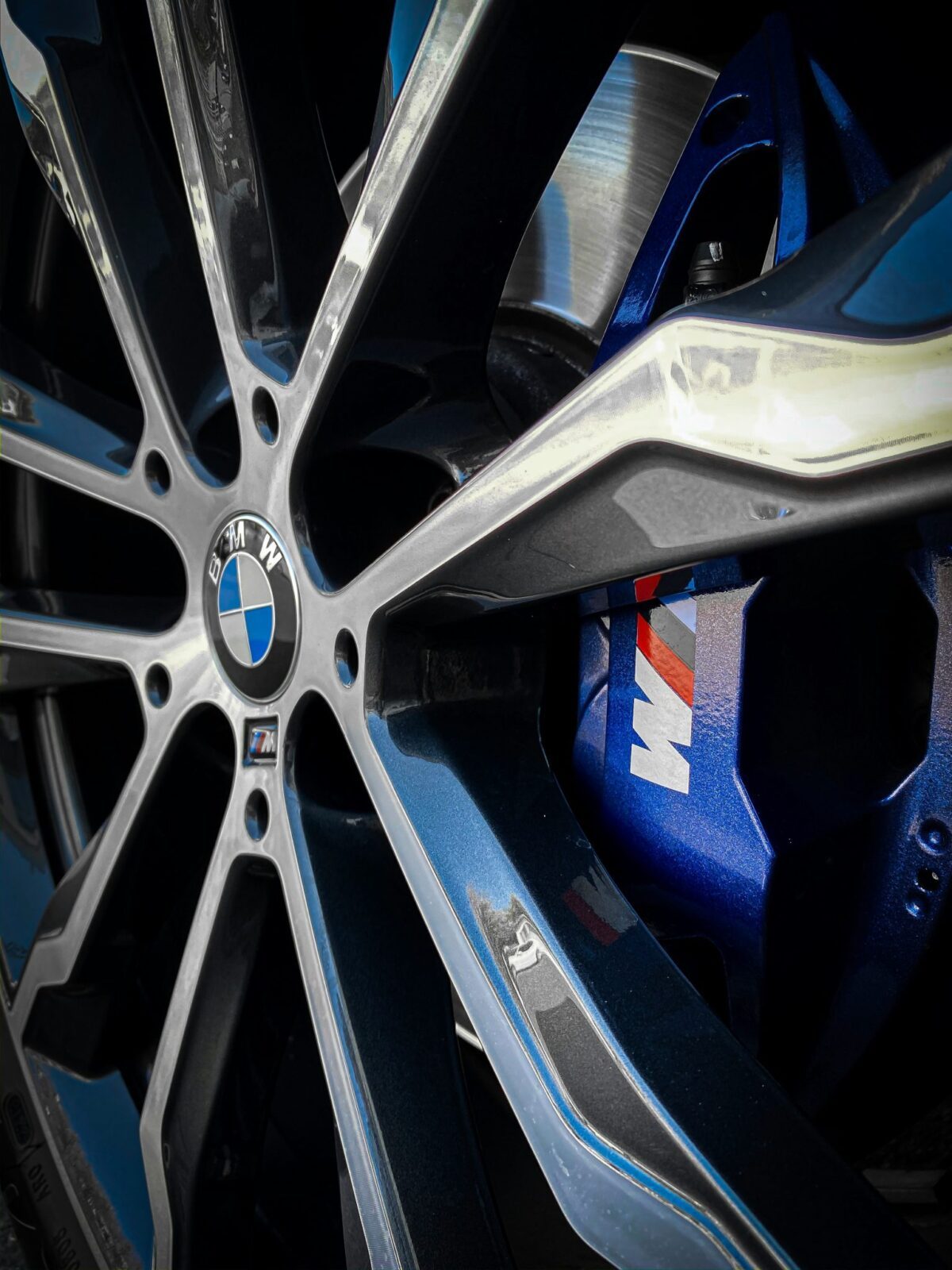 Gros plan sur une jante BMW M Performance et étrier de frein bleu illustrant la personnalisation et les accessoires d’origine BMW