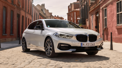 BMW Série 1 blanche stationnée dans une rue pavée du centre-ville de Toulouse, idéale pour la conduite urbaine