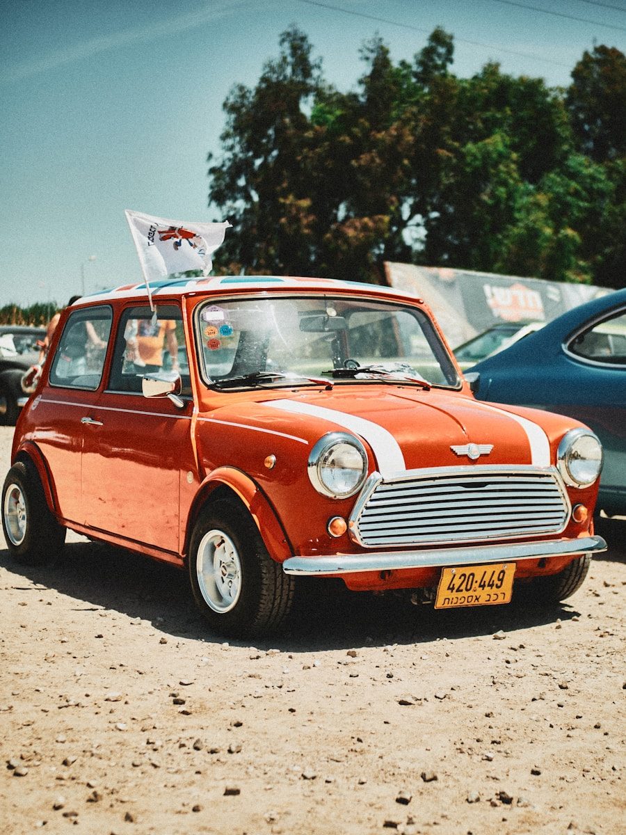 Mini Cooper rouge ancienne, modèle rare de collection des années 1970, photographiée en extérieur sous le soleil, symbole de la passion Mini.