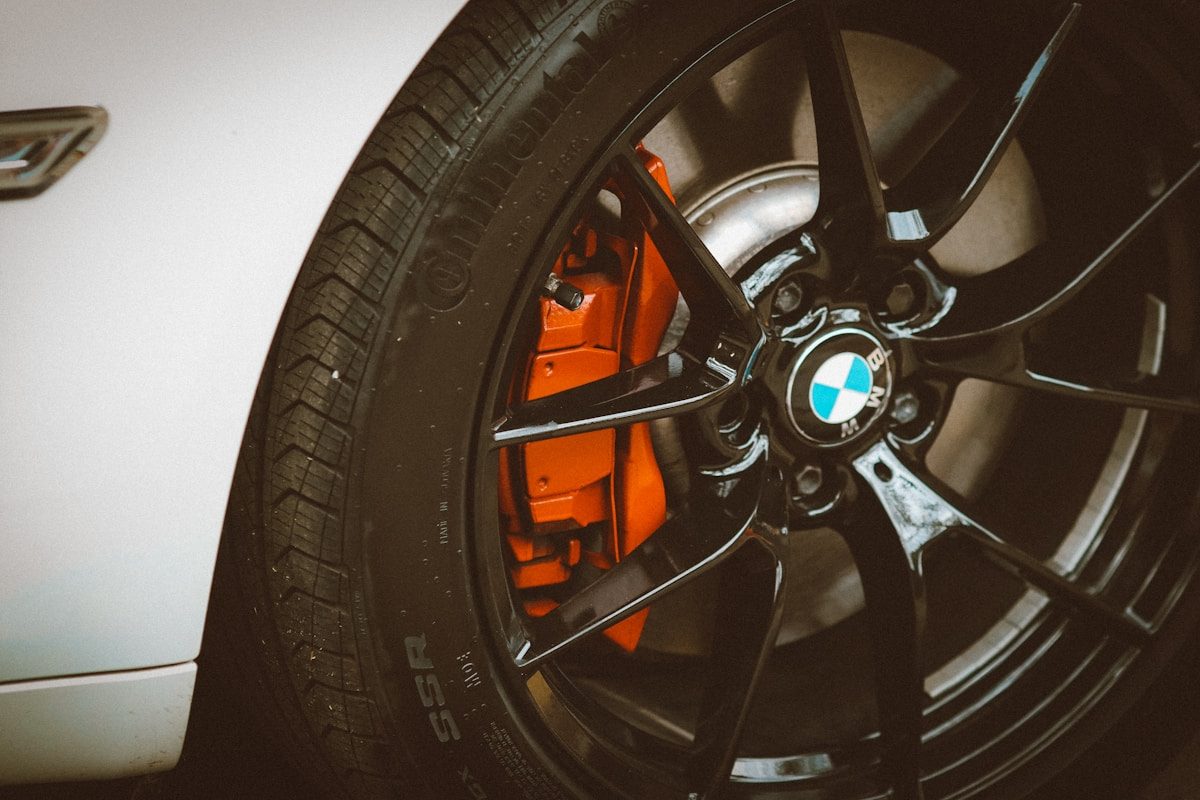 Roue de BMW blanche avec jante M noire et étrier de frein orange illustrant la vérification de l’état des pneus