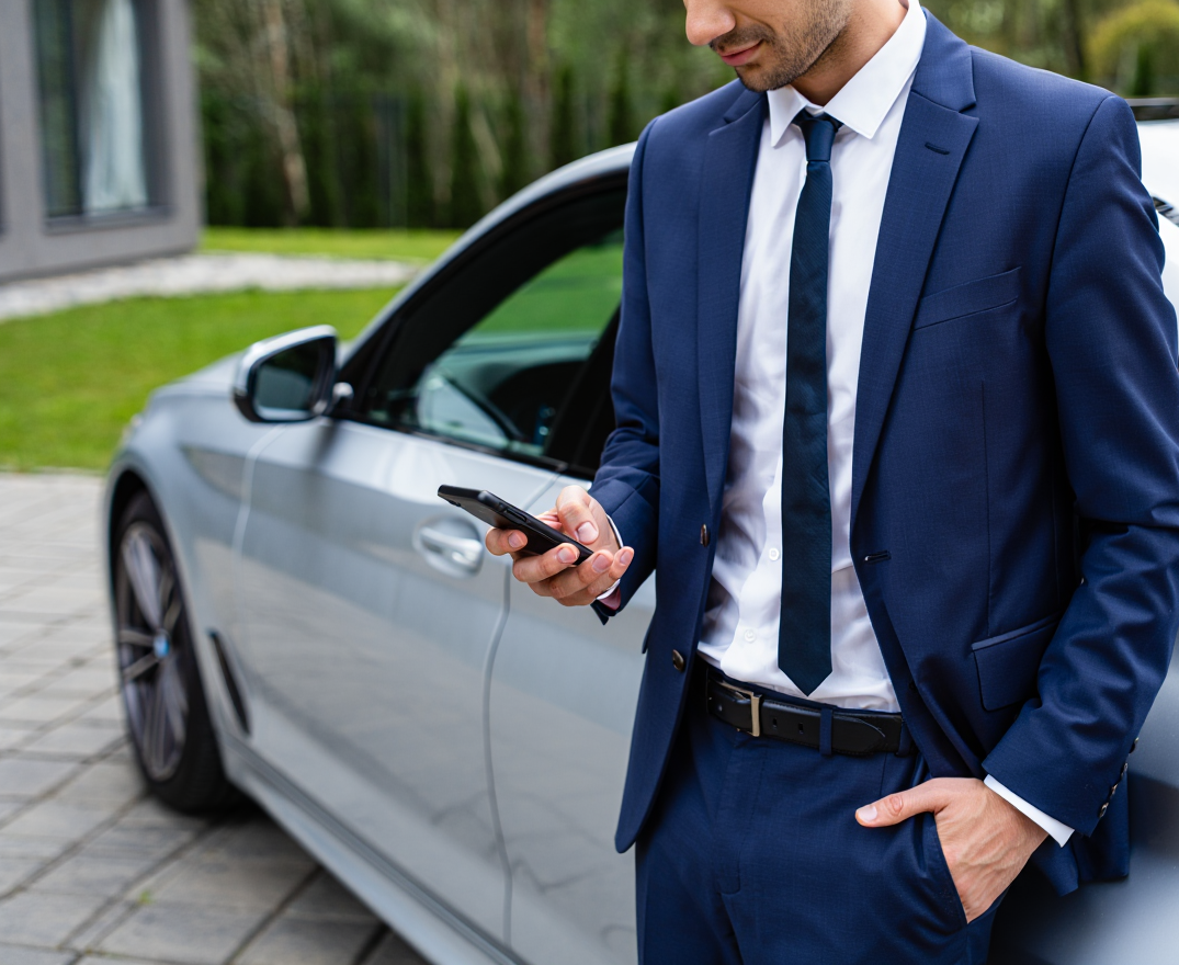 Client BMW consultant son smartphone pour prendre rendez-vous en ligne devant sa voiture